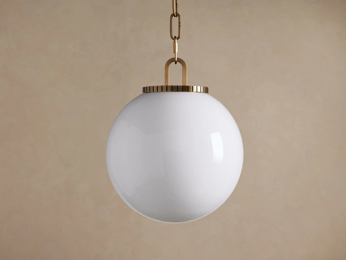 Wescott Globe Pendant with Chain; a white milk glass globe hangs from a brass chain and ribbed brass fixture.