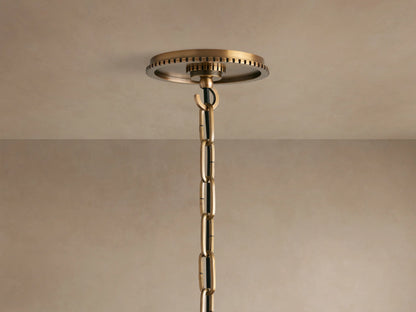 Wescott Globe Pendant close-up: Textured brass ring with dark vertical stripes connecting to a milky white glass globe.