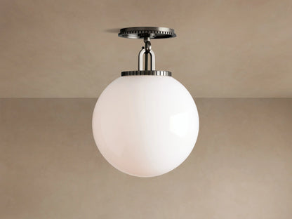 Wescott Globe Flush Mount with opaque white milk glass sphere and dark bronze hardware, against a light brown ceiling.