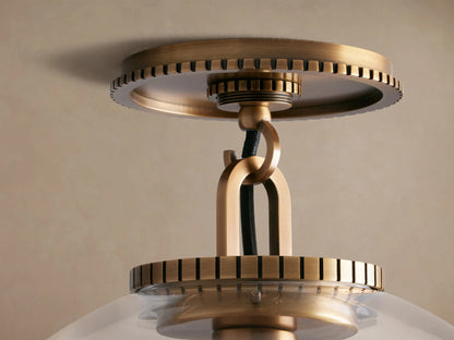 Wescott Globe Flush Mount, brass hardware, clear glass globe with visible filament bulb, against a beige ceiling.