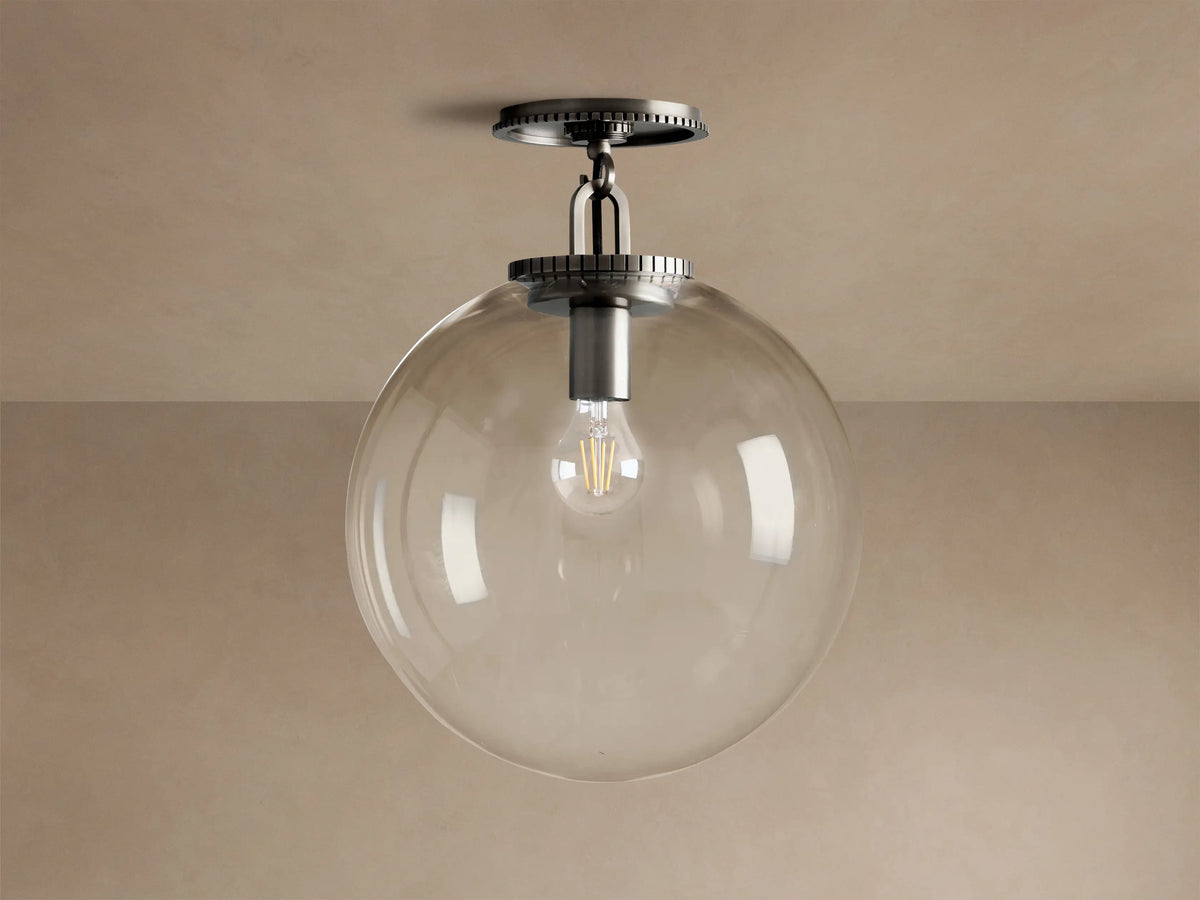 Wescott Globe Flush Mount with clear glass globe, dark bronze hardware, and visible Edison bulb hanging from a ceiling.