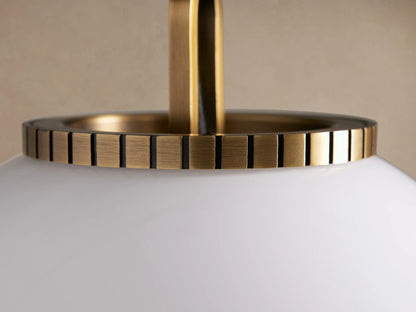 Wescott Globe Pendant with Chain, a large white milk glass globe with ridged brass fitting & brass chain, against beige wall.
