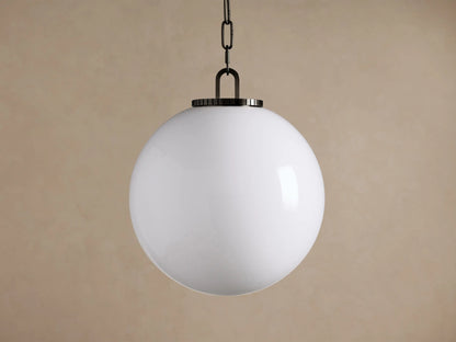 Wescott Globe Pendant: Large white spherical milk glass globe suspended by a dark metal chain against a beige wall.