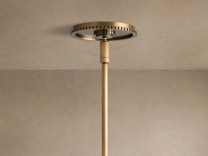 Close-up of Wescott Globe Pendant's brushed brass ring with black grooves, connecting to a white milk glass globe, brass rod.