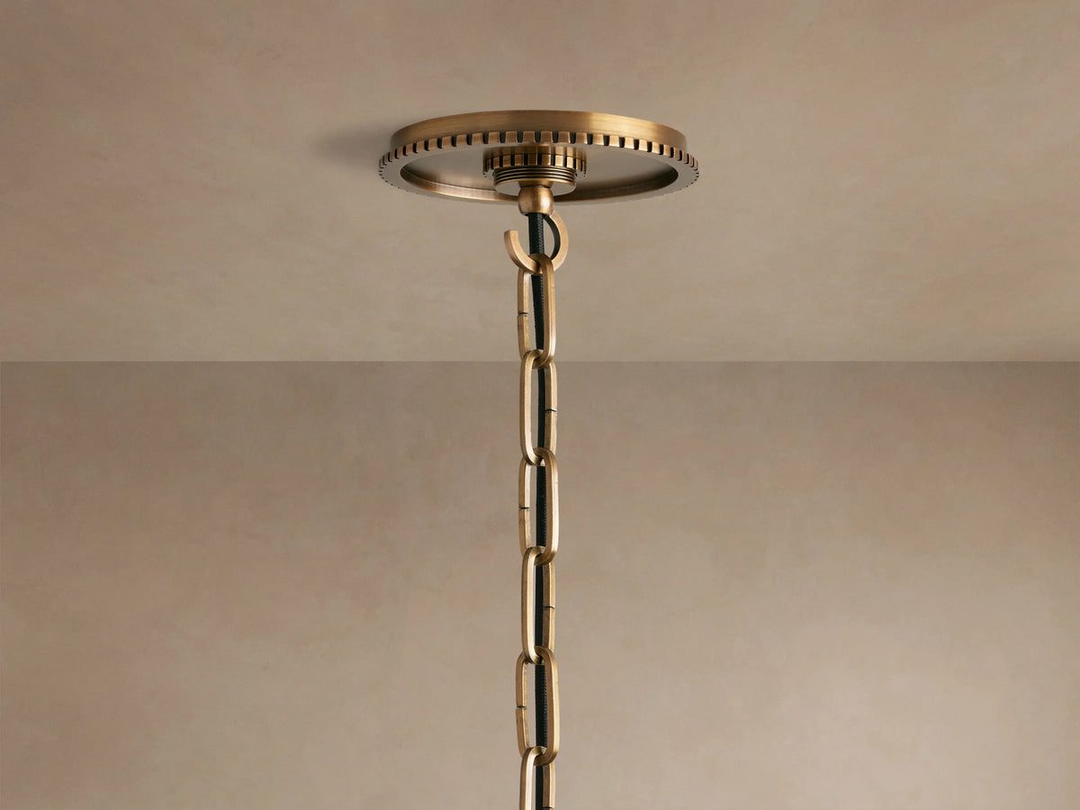 Wescott Globe Pendant close-up: smoky clear glass globe, aged brass top fitting with textured ring, central rod, and visible bulb.