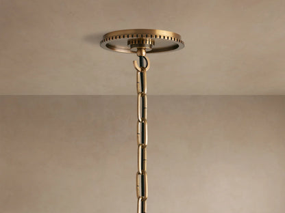 Wescott Globe Pendant close-up: smoky clear glass globe, aged brass top fitting with textured ring, central rod, and visible bulb.