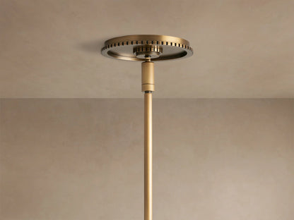 Close-up of Wescott Globe Pendant, milky white glass globe connected to a brushed brass metal band with vertical grooves and rod.