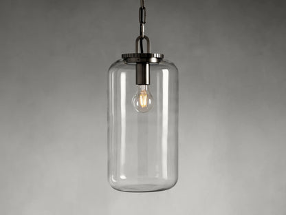 The Wescott Cylinder Pendant features a clear glass cylinder shade with visible filament bulb and brass or bronze fittings, suspended by a chain.