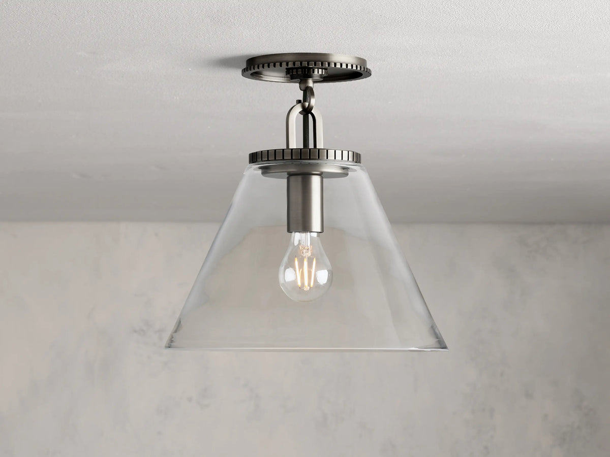 Wescott Cone Flush Mount with clear glass cone shade, visible bulb, and brass finish, mounted on a white ceiling.