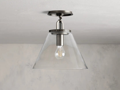 Wescott Cone Flush Mount with clear glass cone shade, visible bulb, and brass finish, mounted on a white ceiling.