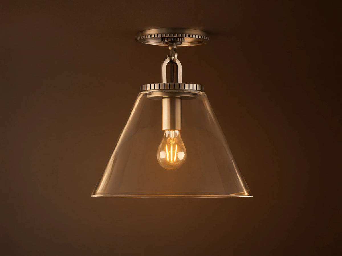 Wescott Cone Flush Mount with clear glass cone shade, visible bulb, and brass finish, mounted on a white ceiling.