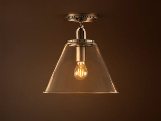 Wescott Cone Flush Mount with clear glass cone shade, visible bulb, and brass finish, mounted on a white ceiling.