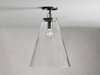 Clear glass cone shade flush mount light with visible bulb, metal fixture in dark finish, attached to white ceiling.