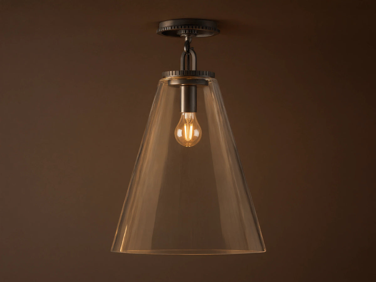 Clear glass cone shade flush mount light with visible bulb, metal fixture in dark finish, attached to white ceiling.
