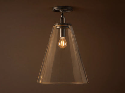 Clear glass cone shade flush mount light with visible bulb, metal fixture in dark finish, attached to white ceiling.