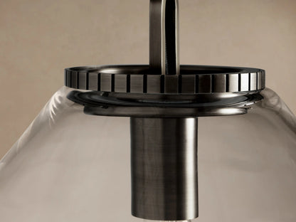 Wescott Cone Pendant with clear conical glass shade, dark bronze metal chain, and exposed Edison bulb against a light wall.