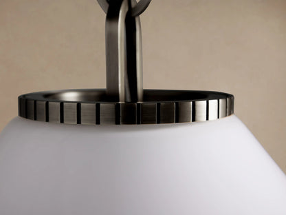 Wescott Cone Pendant with a white milk glass cone shade & dark bronze-finish fixture, suspended by a chain on a beige wall.