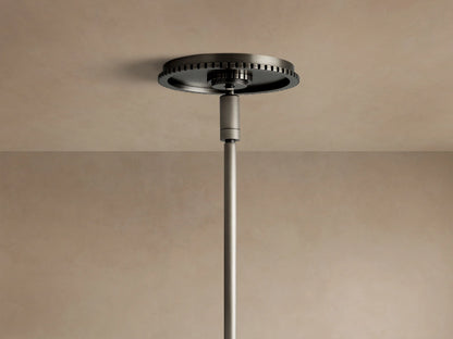 Close-up of Wescott XL Globe Pendant. Large white milk glass globe, dark bronze cap, and hanging rod against a beige wall.