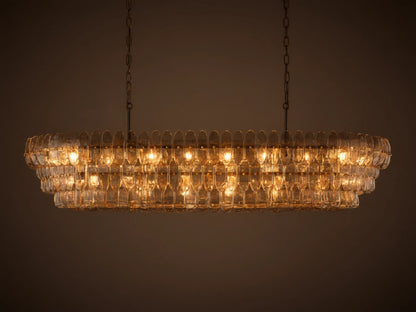 Ghiaccio Oval Chandelier: clear textured glass in tiered wavy segments, suspended by dark chains, with a soft inner glow.