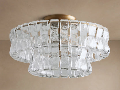 Ghiaccio Flush Mount: Brass base with clear, wavy textured glass strips in a layered, sculptural design, illuminated.