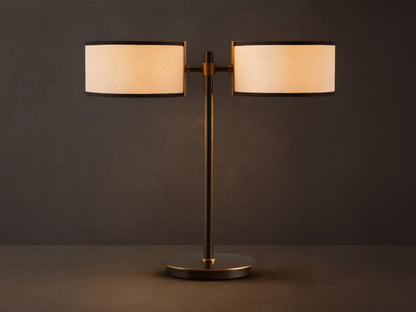 Daphne 2-Light Table Lamp with black-finished base and two white linen shades with black trim on a wooden surface.