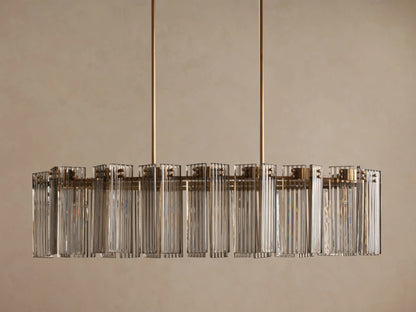 Delsie Oval Chandelier: large oval light fixture with clear fluted glass rods and a burnished brass frame, hanging from two rods.