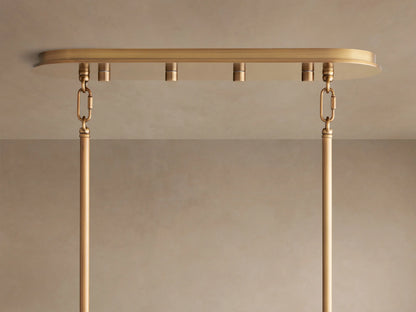 Close-up of Delsie Oval Chandelier's burnished brass oval ceiling canopy, with two hanging rods suspended by chain links.