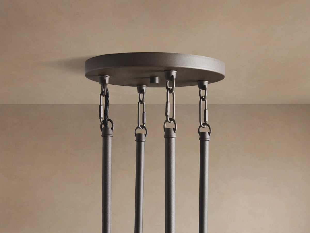 Andreas Round Chandelier close-up: dark gray frame, clear ribbed glass cylinders, visible warm filament bulbs.