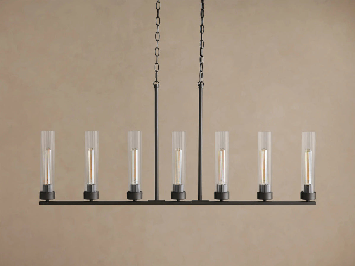 Andreas Linear Chandelier: Black metal linear bar with 7 clear ribbed glass shades & filament bulbs, suspended by chains.