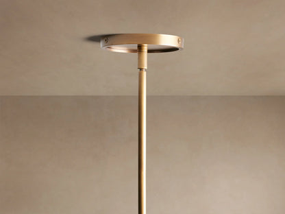 Close-up of Theron Linear Chandelier with warm brass finish, clear conical glass shades, and glowing filament bulbs.