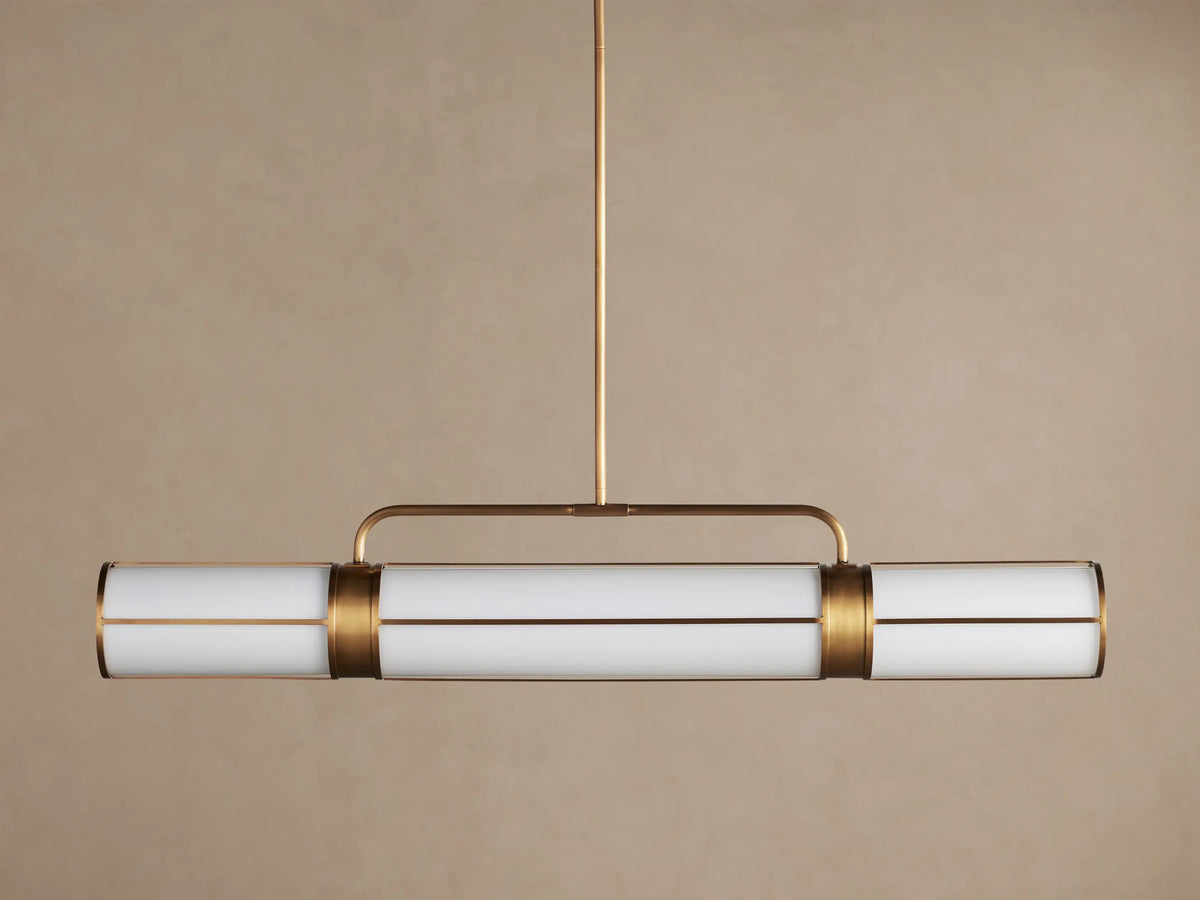 Remming Linear Chandelier: horizontal fixture with three glowing milk glass shades and burnished brass framework.