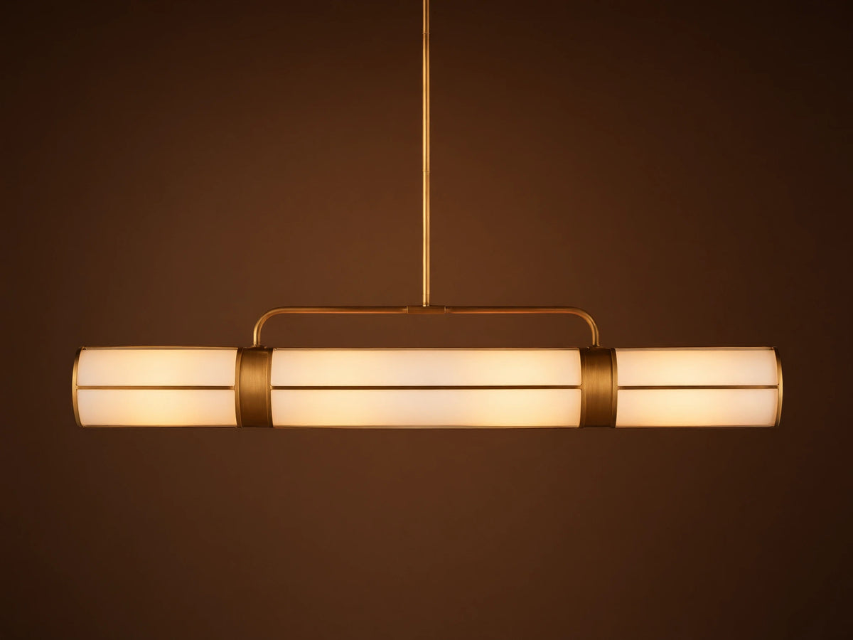 Remming Linear Chandelier: horizontal fixture with three glowing milk glass shades and burnished brass framework.