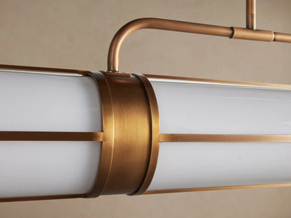 Remming Linear Chandelier with two white milk glass cylindrical diffusers, framed by burnished brass, hanging from brass rods.