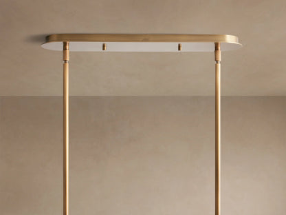 Close-up of a Remming Linear Chandelier, showing its long milk glass cylinder encased in burnished brass details and suspension arm.