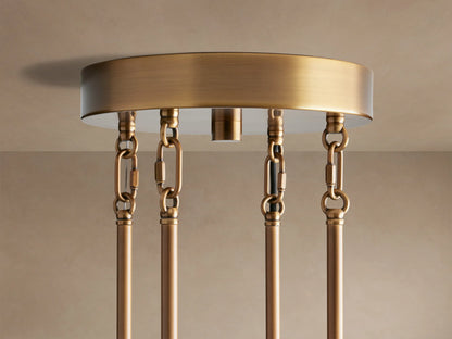 Close-up of Delsie Round Chandelier with burnished brass frame and numerous ribbed, smoky glass rods glowing warmly.