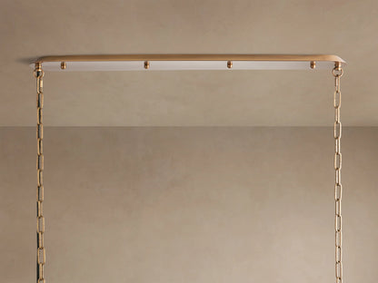Shelton Linear Chandelier: White fabric shade with burnished brass frame and suspension rods, viewed from a low angle.