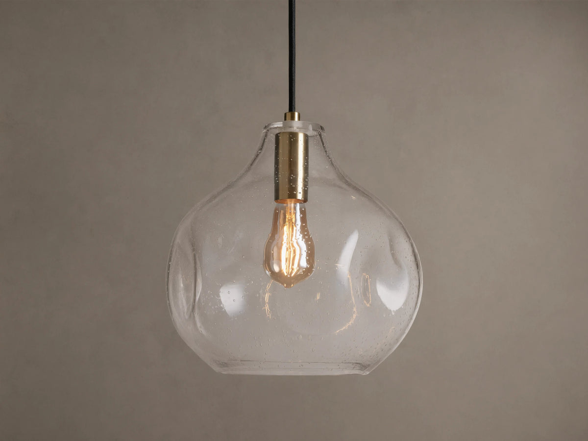 Organic 12" Pendant: Clear, mouth-blown seeded glass, organic-shaped shade with brass fitting, black cord, and warm vintage bulb.