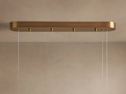 Halima Linear Chandelier with a glowing alabaster stone finish, suspended by steel cables, creating a warm ambiance.