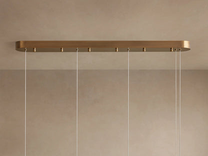 Halima Linear Chandelier with glowing alabaster stone tube, mounted by two steel cables against a neutral background.