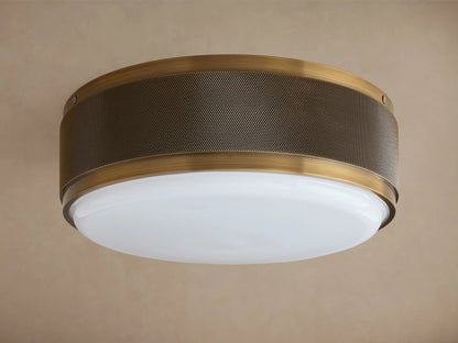 Ceiling light fixture with a dark bronze finish and perforated metal drum shade; glowing white glass diffuser underneath.