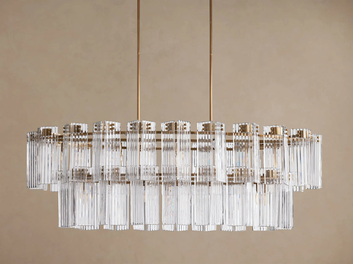 Delsie Oval Tiered Chandelier with burnished brass frame, two tiers of clear fluted glass rods, and visible bulbs.