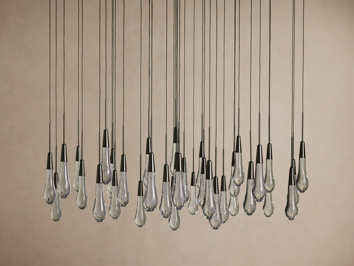 Teardrop-shaped glass bulbs suspended from long cords, forming the Soltaire Round Chandelier with a sleek, modern design.