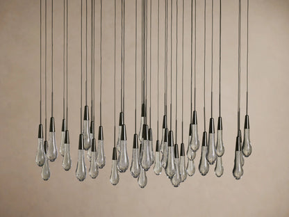 Teardrop-shaped glass bulbs suspended from long cords, forming the Soltaire Round Chandelier with a sleek, modern design.