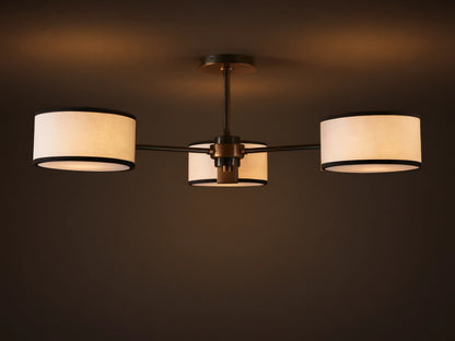 Daphne Flush Mount: 3 white linen shades with black trim, dark bronze frame, lit against a grey ceiling.