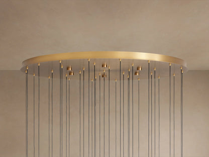 Soltaire Round Chandelier. Large brass-finished round plate with numerous thin black cords hanging down from golden fittings.