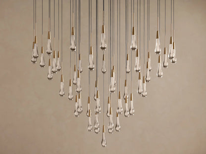 Soltaire Round Chandelier with many clear, textured teardrop-shaped LED bulbs, brass-finished tops, hanging at various lengths.