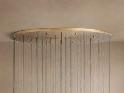 Soltaire Round Chandelier: large, round, golden brass ceiling plate mounted to a light ceiling, with numerous thin dark wires hanging down.