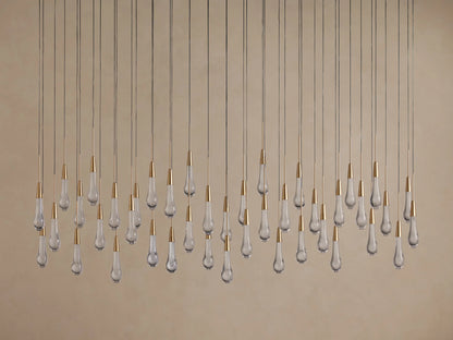 Linear Soltaire Chandelier with numerous clear glass teardrop bulbs, brass caps, hanging from thin wires at varied lengths.