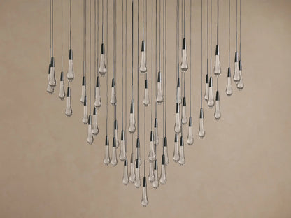Soltaire Round Chandelier with multiple clear, textured, teardrop glass bulbs, dark metallic caps, suspended at varying lengths.