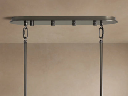Close-up of Delsie Oval Tiered Chandelier with clear fluted glass rods, dark metal frame, and warm light glowing.